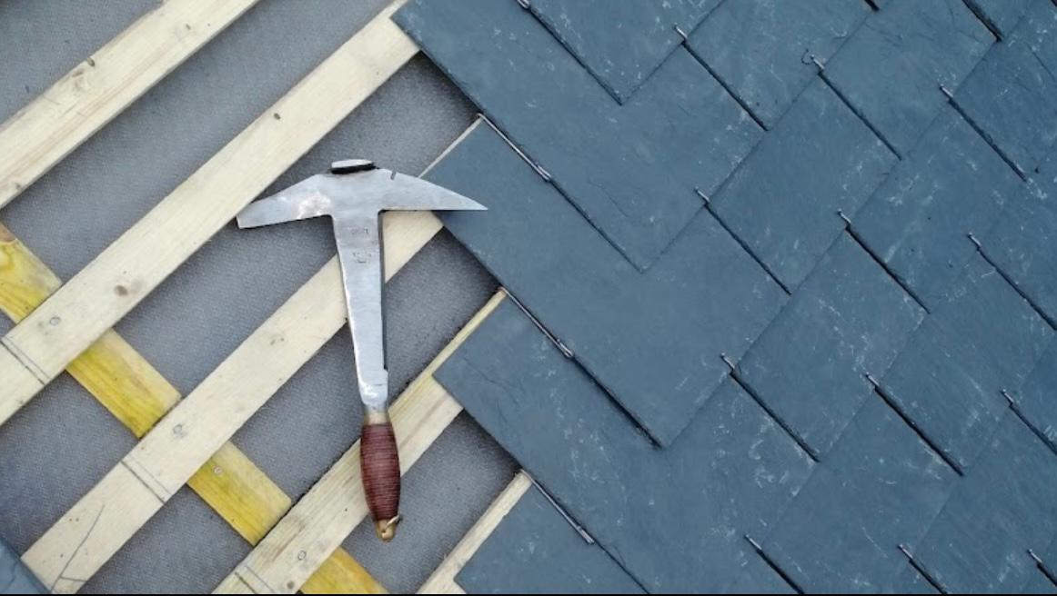 Outil de couvreur sur une toiture en ardoise
